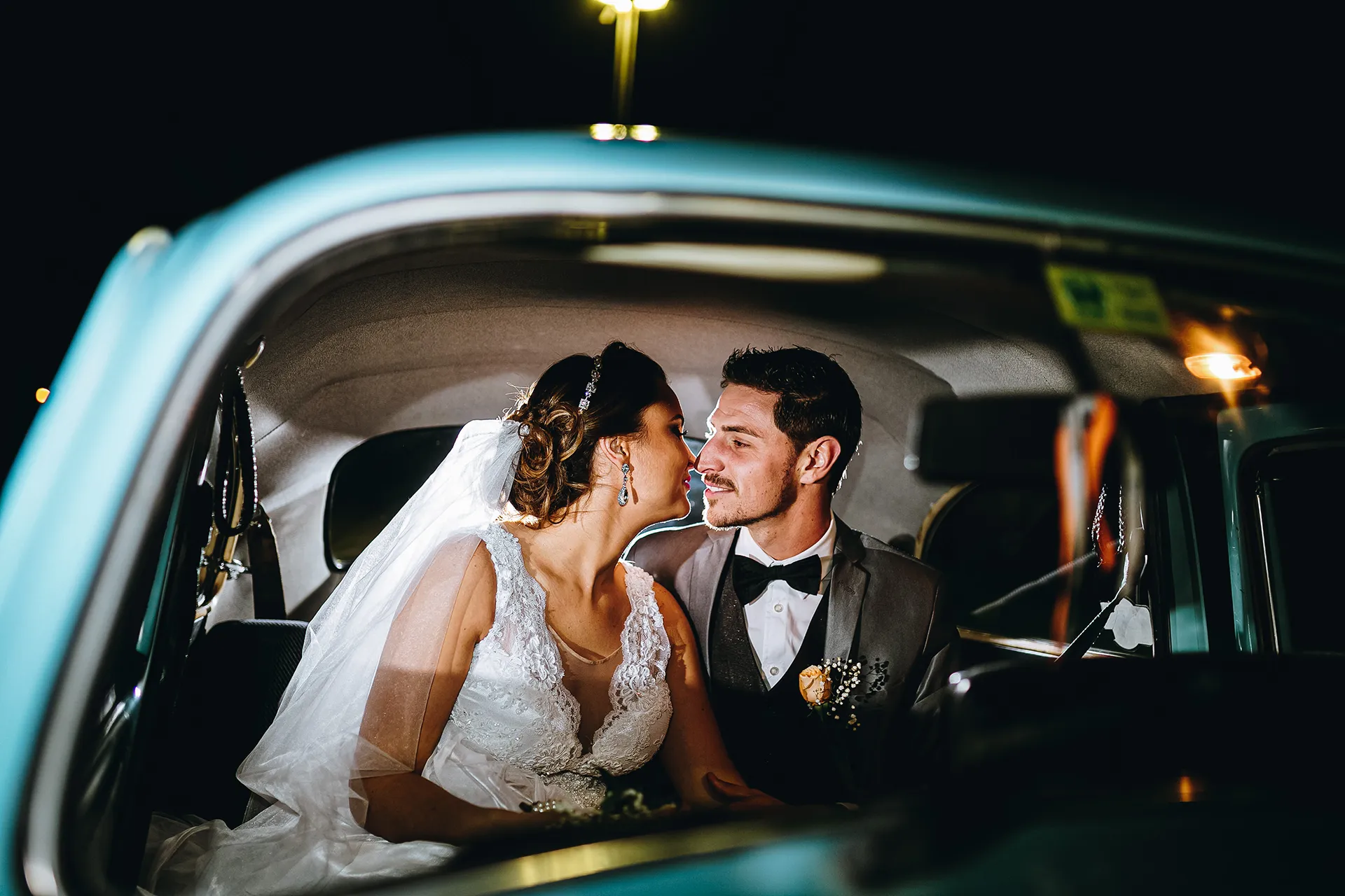 Casal em um momento íntimo dentro de um carro clássico