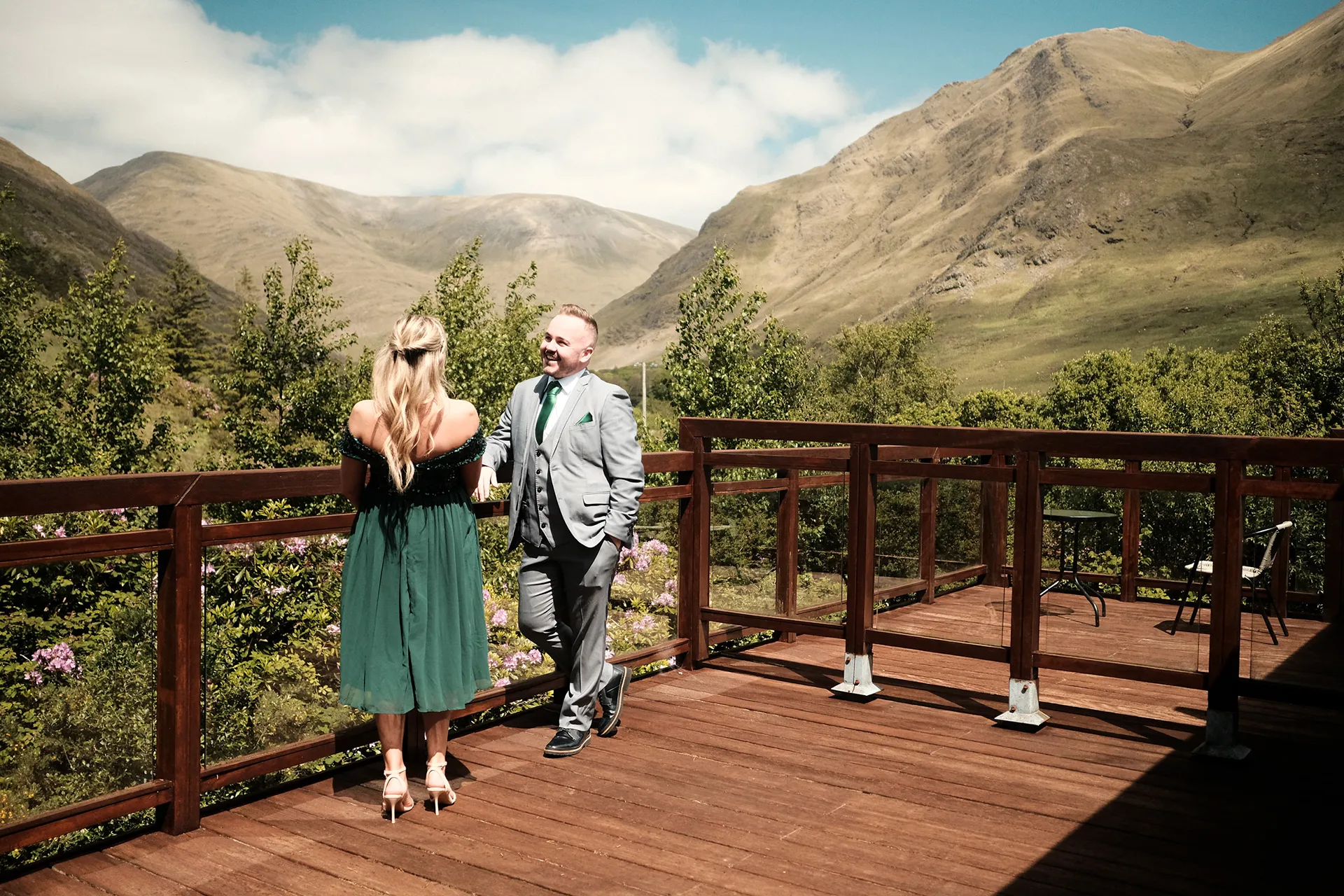 Casal e convidados diante de uma paisagem entre montanhas